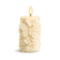 Decorative candle with butterfly and floral designs on a white background
