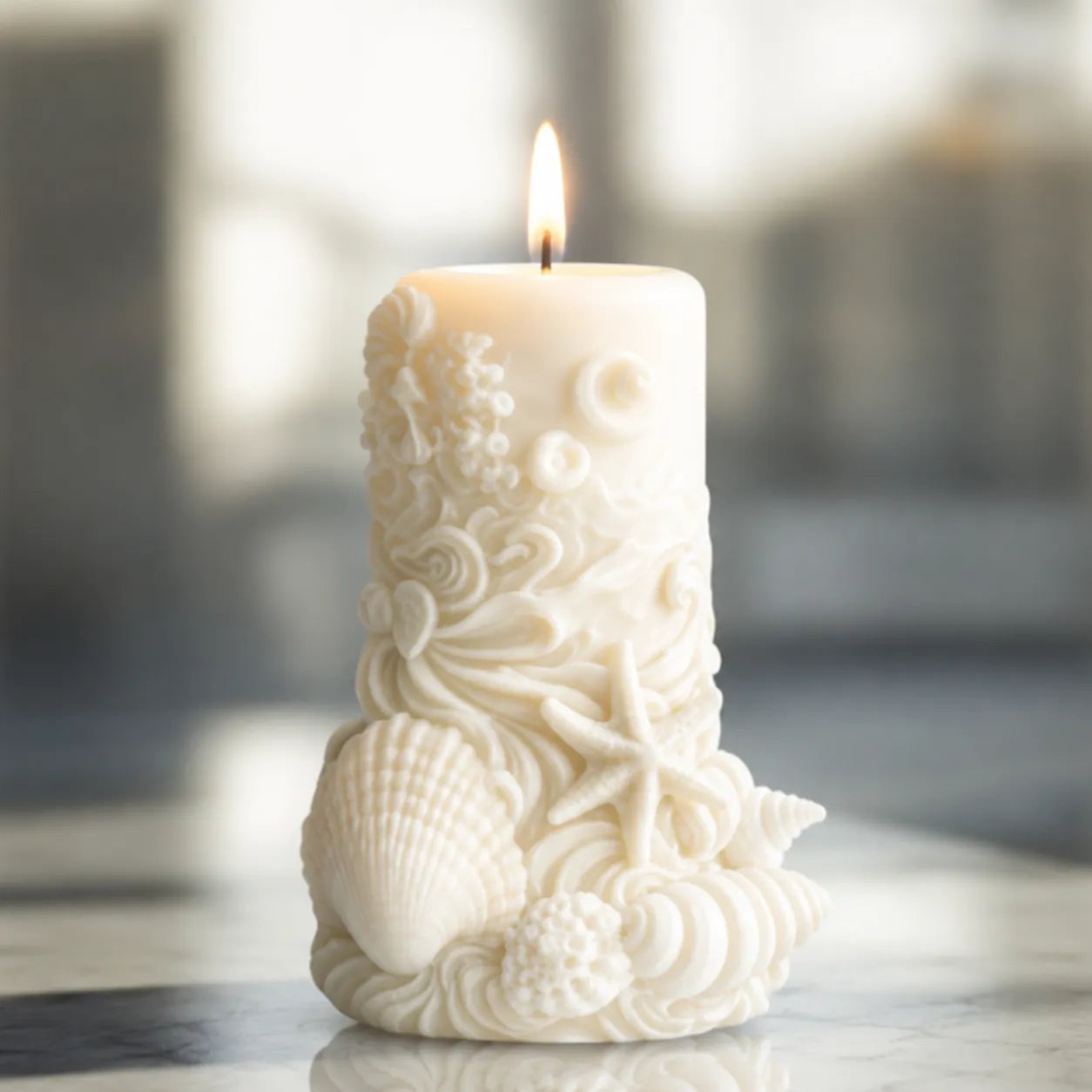 Decorative candle with shell and starfish design on a marble surface