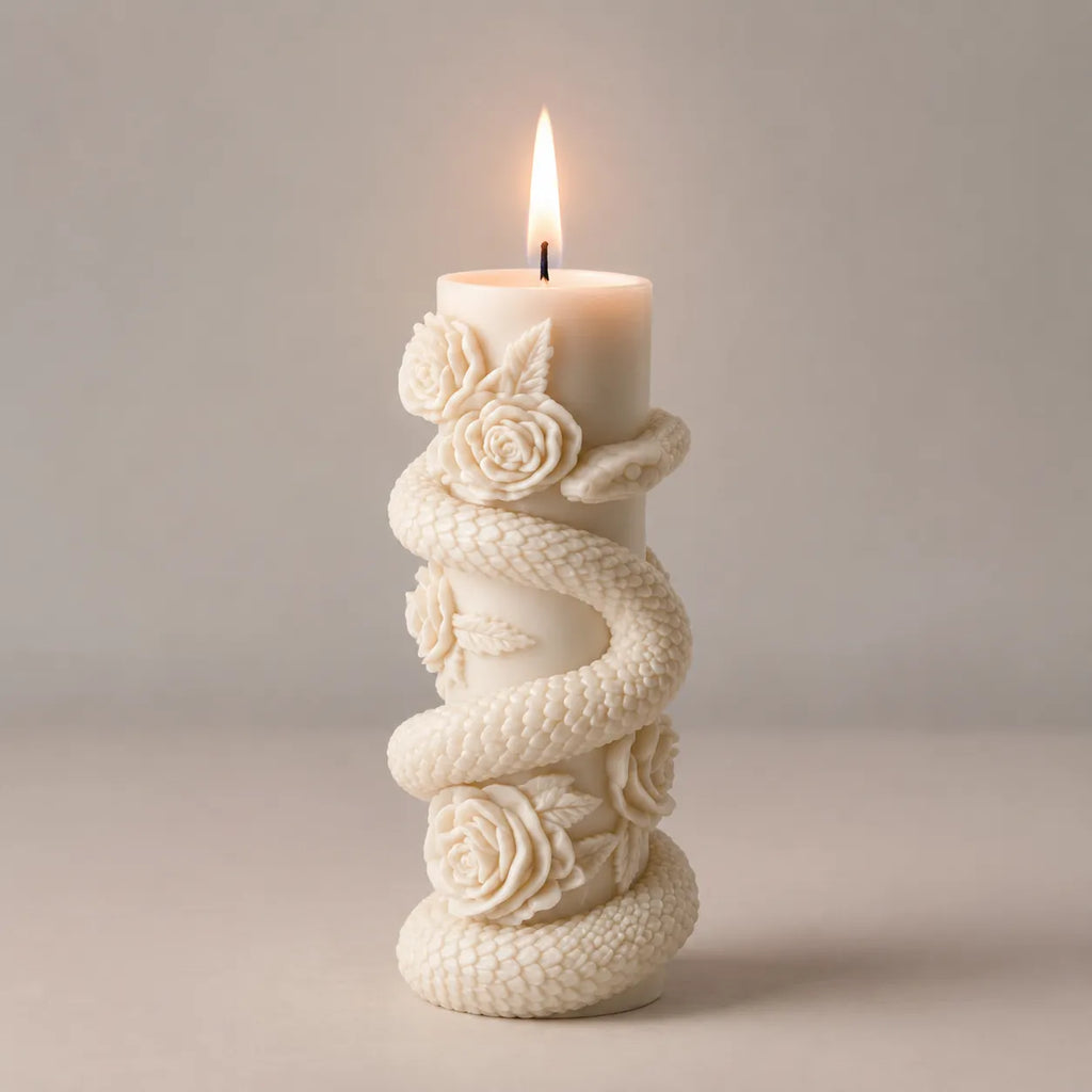 Decorative candle holder with floral designs and a lit candle on a neutral background