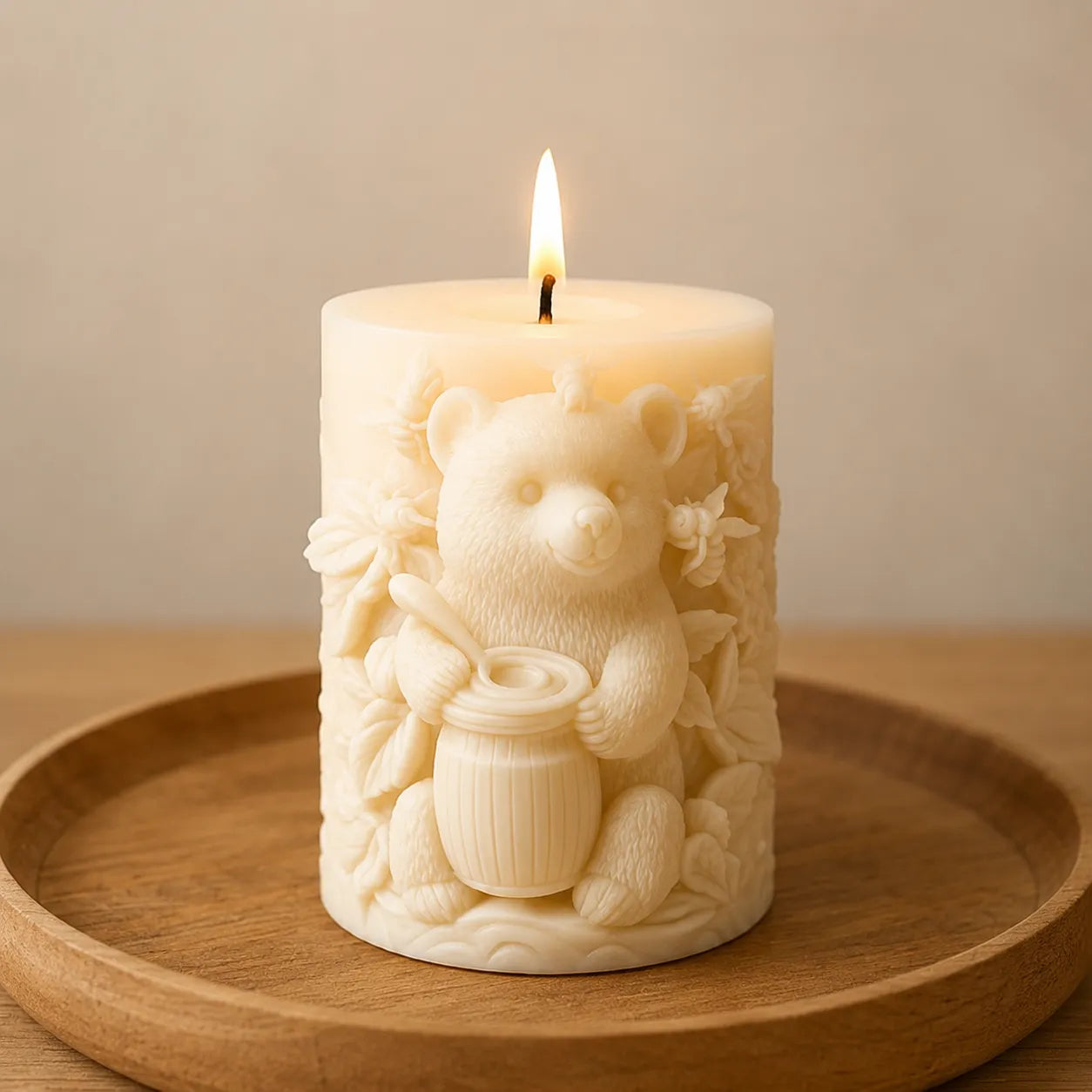 Decorative candle with a bear design on a wooden tray against a beige background