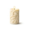 Decorative candle with embossed design on a white background