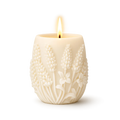 White candle with floral embossing on a white background